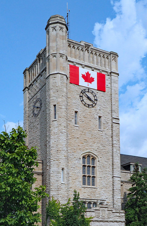A tall stone building with a Canadian flag on it.